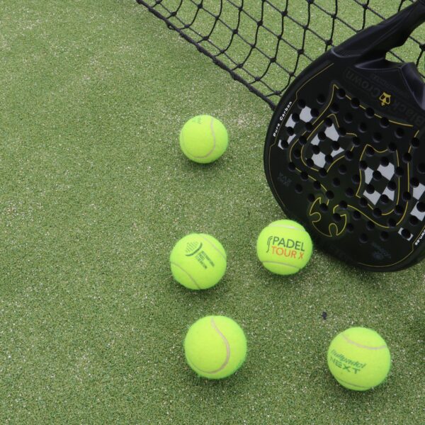 6 padel balls and a black racket